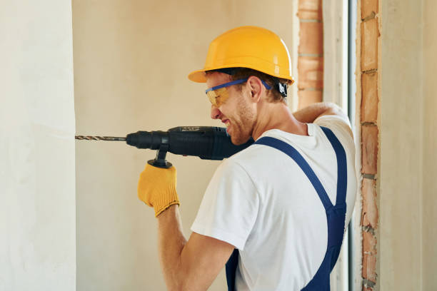 istock Holding drill. Young man working in uniform at construction at daytime 1369353333