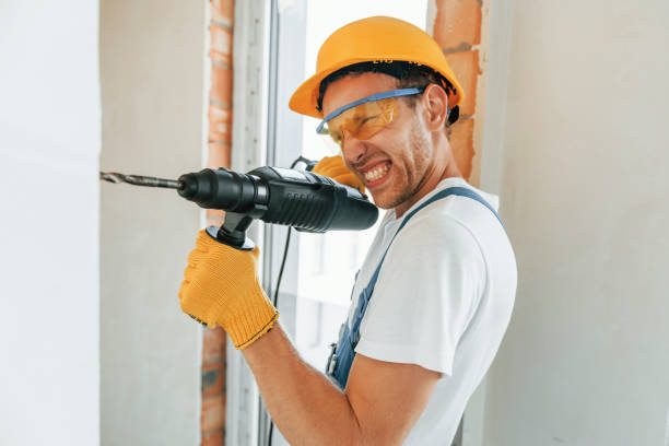 istock Professional service. Young man working in uniform at construction at daytime 1369353338