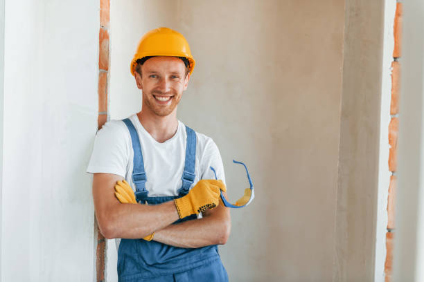 istock Professional service. Young man working in uniform at construction at daytime 1369353339