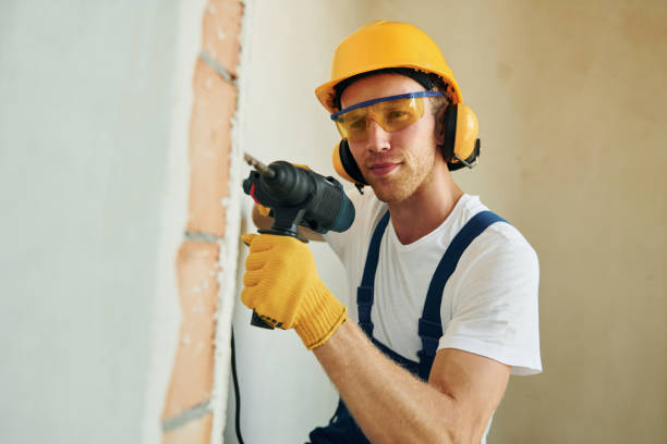 istock Modern repair. Young man working in uniform at construction at daytime 1369353404