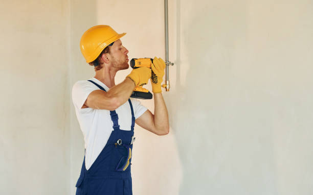 istock Indoors in unfinished room. Young man working in uniform at construction at daytime 1369353804