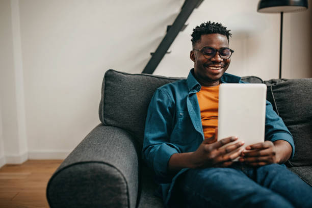istock Young men using technology  in the living room 1369353920