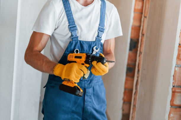 istock Empty walls. Young man working in uniform at construction at daytime 1369354173