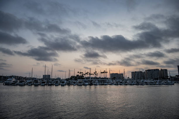 Sunset in Marina del Rey marina with building silhouette.