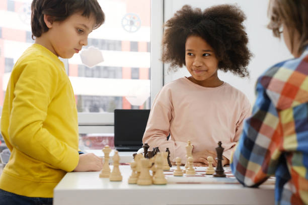 istock multiethnic kids playing chess board game at school 1369355219