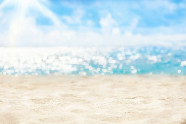 istock Tropical natural blurred background of summer beach. Vacation concept. Sunlight, white sand, ocean water sparkles against blue sky. 1369355334