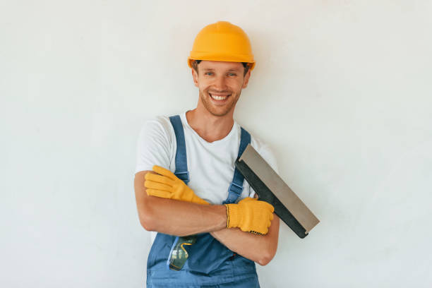 istock Posing for the camera. Young man working in uniform at construction at daytime 1369355767