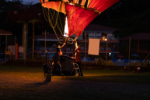 large hot air balloon is in the farm of santa fe de antioquia. it is inflated with fire to achieve its elevation and have family fun