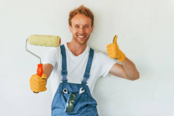 istock Against white walls. Young man working in uniform at construction at daytime 1369356661