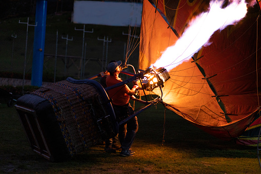 Flame from a propane burner inflating a hot air balloon in preparation for a dawn flight