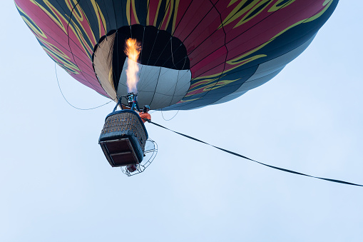 large hot air balloon is in the air flying with people inside its basket enjoying a ride in the air