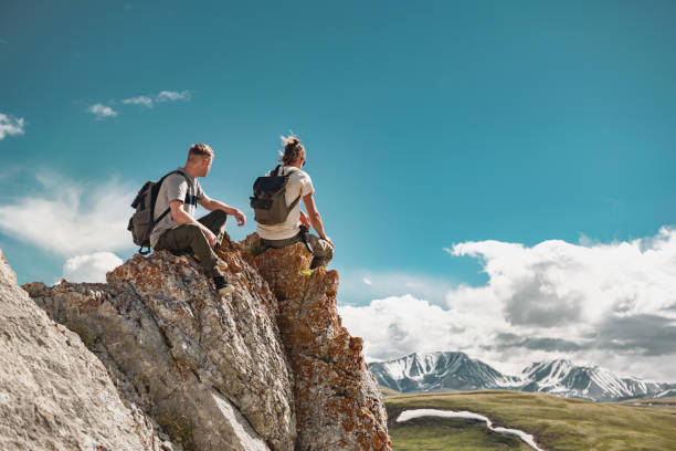 young hikers relax at big rock or cliff - travel scenics landscape observation point imagens e fotografias de stock
