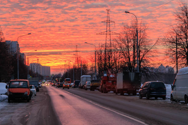 Beautiful fiery clouds sunset reflects in the wet asphalt in Moscow, Russia