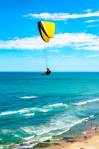 Paraglider flight over the beach in the city of Torres in Rio Grande do Sul with the sea and horizon in the background