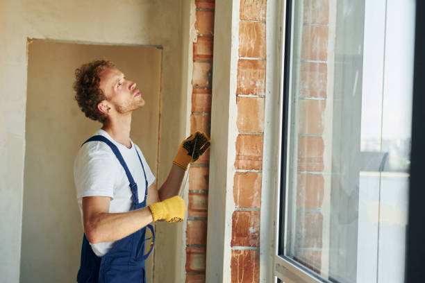 istock In protective gloves. Young man working in uniform at construction at daytime 1369358641