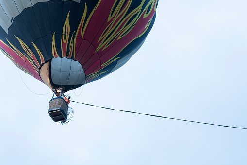 large hot air balloon is in the air flying with people inside its basket enjoying a ride in the air