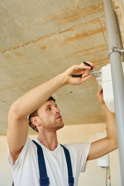istock Repaiting the pipes. Young man working in uniform at construction at daytime 1369358743