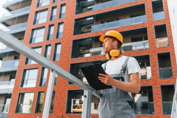 istock With documents in hands. Young man working in uniform at construction at daytime 1369359081