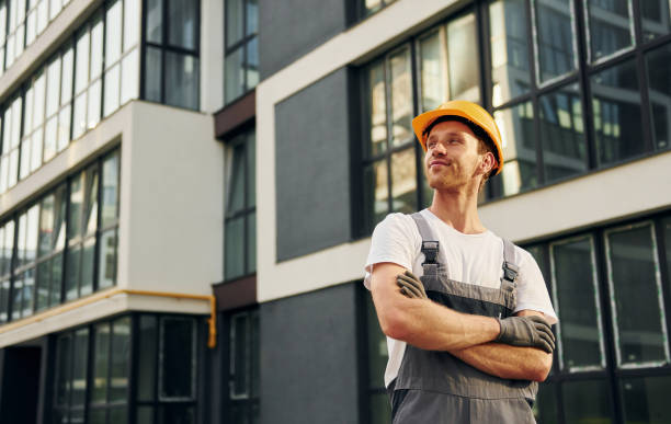 istock Modern exterior. Young man working in uniform at construction at daytime 1369360479