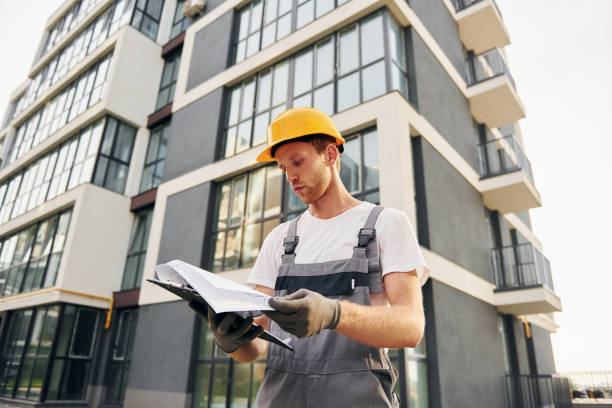 istock Modern city. Young man working in uniform at construction at daytime 1369360526
