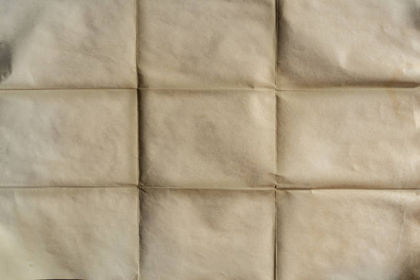 istock Old folded brown yellow paper texture background 1369362627