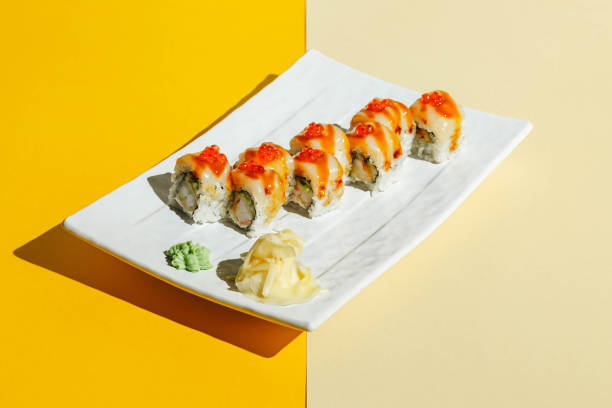 istock Sushi rolls with eel, shrimp, cucumber and cream cheese, decorated with red caviar. Hard light, deep shadow 1369364241