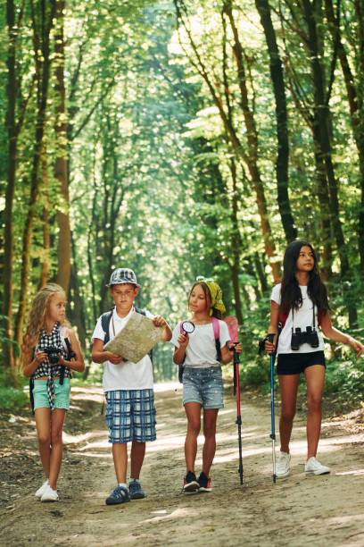 istock With map. Kids strolling in the forest with travel equipment 1369367090