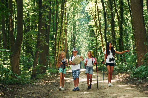 istock With map. Kids strolling in the forest with travel equipment 1369367094