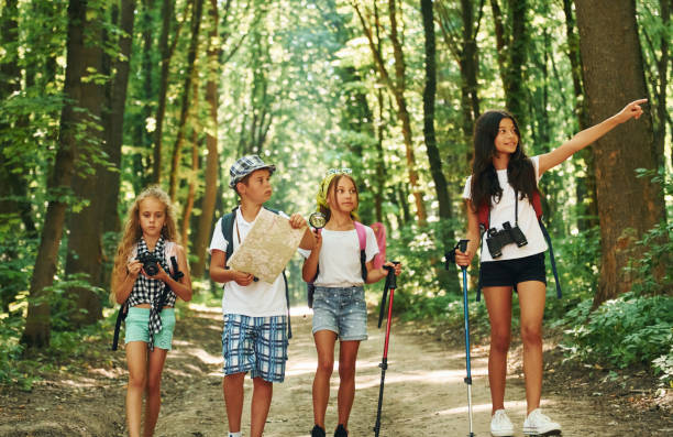 istock With map. Kids strolling in the forest with travel equipment 1369367153