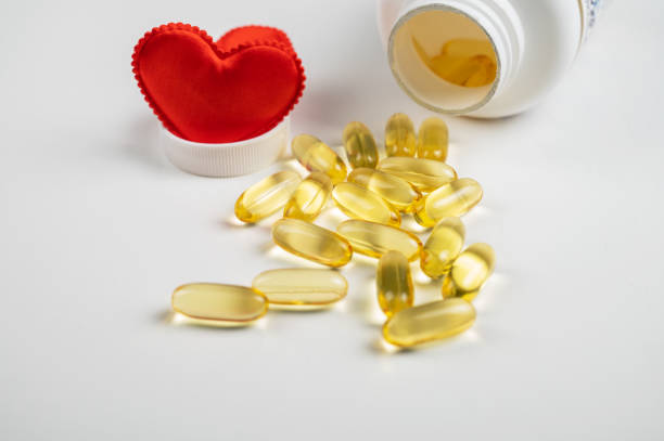 istock Gold fish oil isolated on white background with red hearts 1369367316