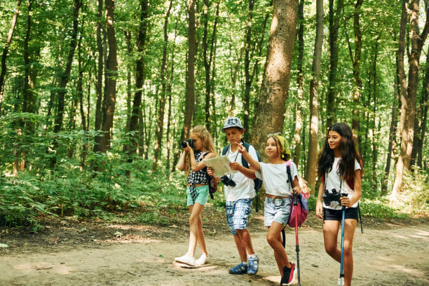 istock Summertime weekend. Kids strolling in the forest with travel equipment 1369367452