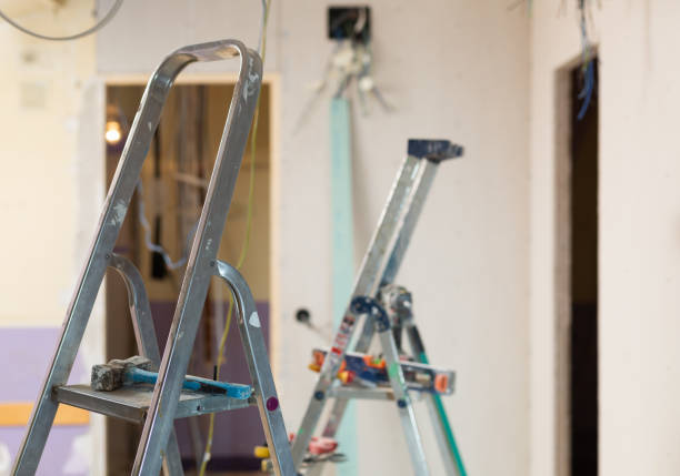 Photo of stepladders with tools in empty room. Reconditioning work in living accommodation.