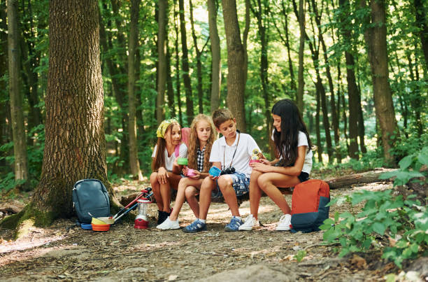istock Taking a break. Kids strolling in the forest with travel equipment 1369368682