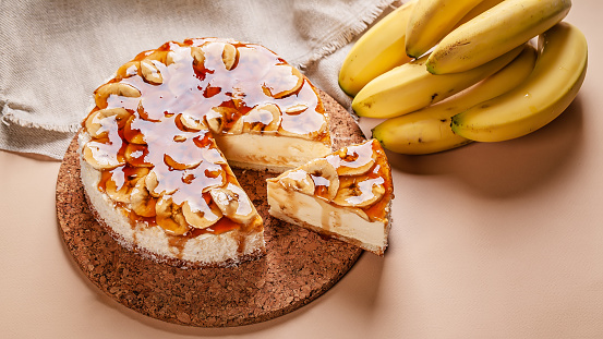 Food banner. Banana cheesecake with caramel on a beige background. Homemade delicious pastries. Sweet tasty dessert. Copy space