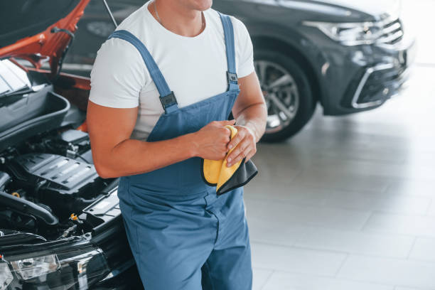 istock In blue uniform. Man is repairing broken automobile indoors 1369374450