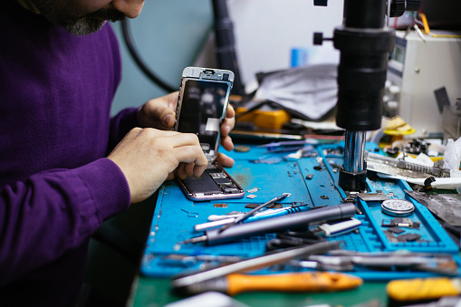 Technician repairing mobile phone