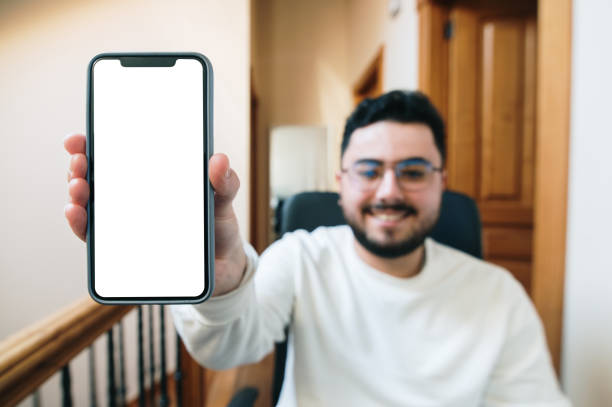 istock Young man showing a blank smart phone screen 1369376409