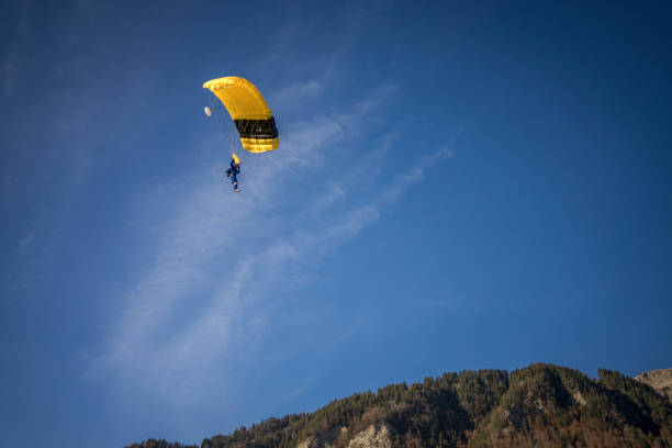 istock Paraglider glides through clear skies, in aerial flight 1369377453