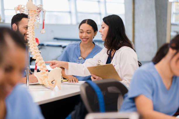 istock In busy classroom, professor helps nursing students 1369379339