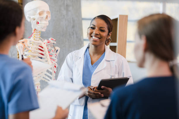 istock Female nursing teacher smiles at unrecognizable student 1369379342