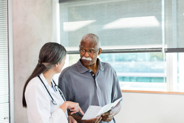 istock Senior man looks at doctor in disbelief while discussing brochure 1369379624