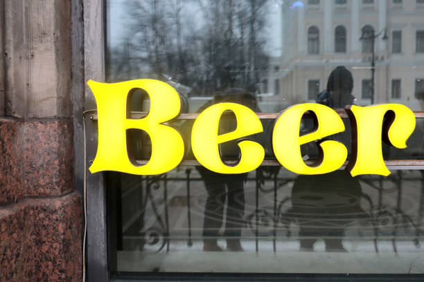 View of glowing beer sign board on window