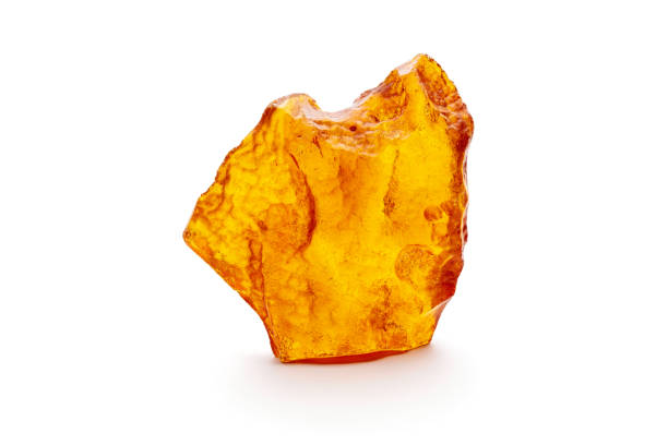 Natural amber. A piece of yellow opaque natural amber on white background. stock photo