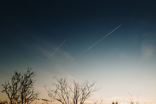 Two airplane trails on a sky at sunset