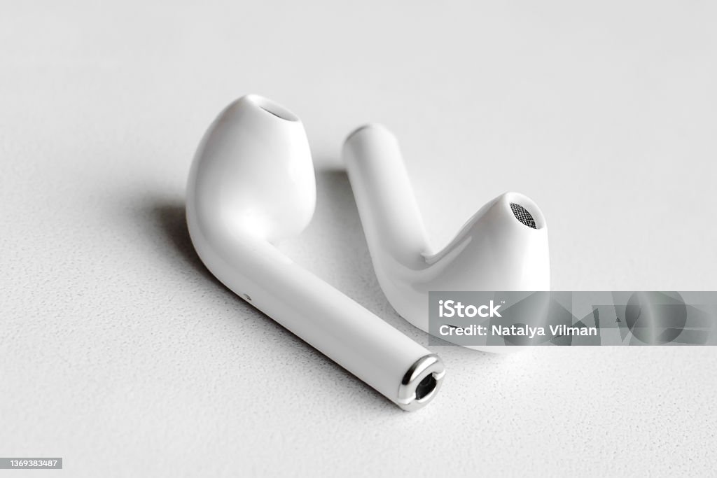 Wireless headphones on a white background, Close-up. The concept of modern technology. Wireless In-ear Headphones Stock Photo