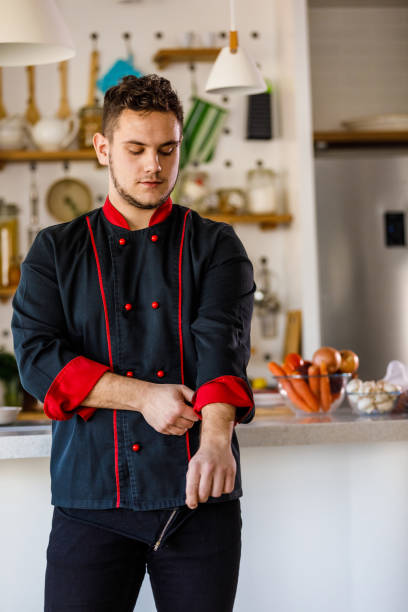 giovane chef uomo fiducioso che si rimbocca le maniche sulla sua uniforme - sleeve rolling rolled up rolled up sleeves foto e immagini stock