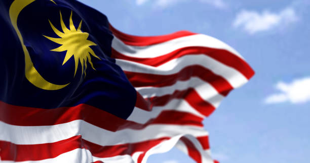 Detail of the national flag of Malaysia waving in the wind on a clear day stock photo