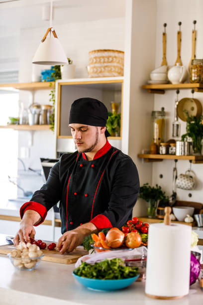 istock Young male chef putting radishes on a cutting board 1369383940