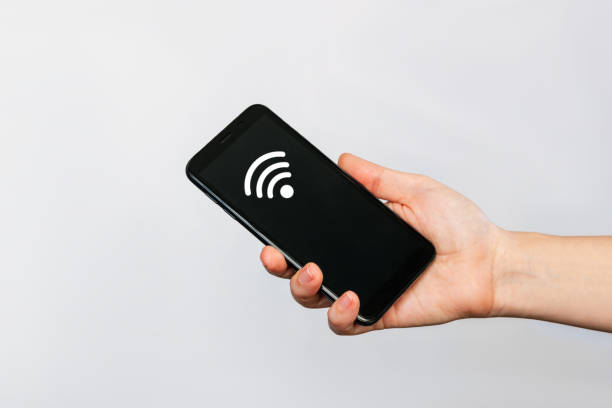 istock Mobile phone with black screen and Wi-Fi icon in a female. Internet connection 1369384658