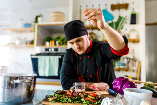 istock Chef adding a pinch of salt on a dish he prepared 1369384847